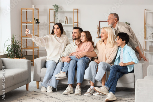 Big family taking selfie on sofa at home