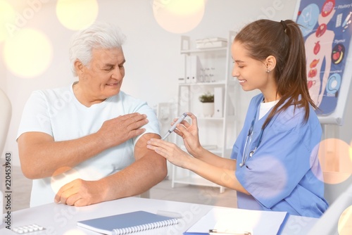 Vaccination and healthcare for seniors, nurse administering injection to elde...