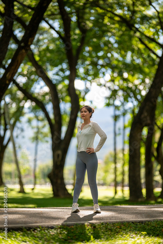 Confident woman standing resting in lush park