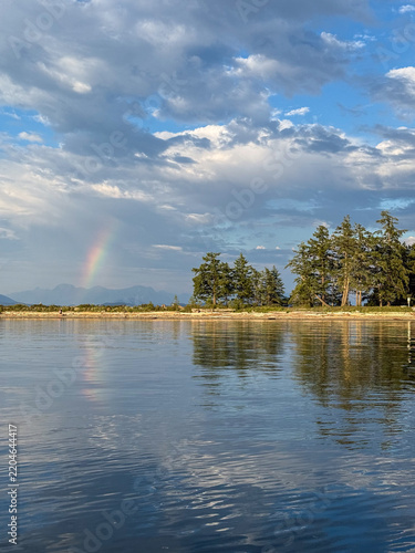 Rainbow reflecting in the water on the coast