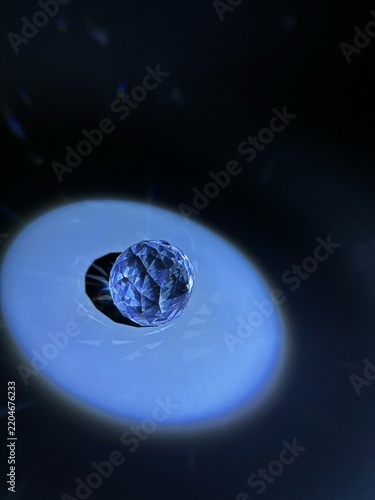 Faceted crystal sphere surrounded by a glowing blue circular light pattern on a dark abstract background.