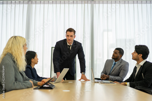 Business colleagues listening to manager at office conference table