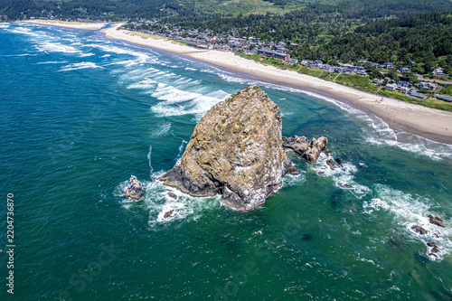 Close Aerial View of Haystack Rock and Needles Above Cannon Beach Town and Shoreline, Oregon