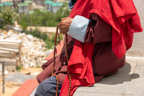 Thimphu Bhutan, older man sitting and moving mala beads through his fingers in a continuous cycle of devotion.
