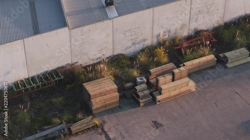 Drone's shadow moving across an industrial warehouse yard
