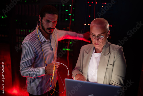 Foto It experts collaborating maintaining network servers in data center