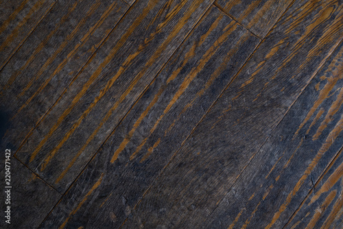 Worn dark brown wooden floorboards with faded finish and diagonal wood grain