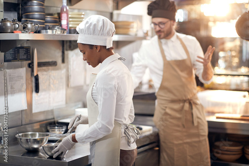 woman chef preparing eggs. Cook in Professional Modern  kitchen, restaurant concept