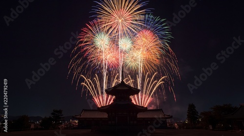 Vibrant fireworks explode over traditional temple pagoda at night
