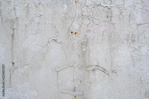 Cracked and peeling white paint texture with old adhesive residue and exposed pink underlayer
