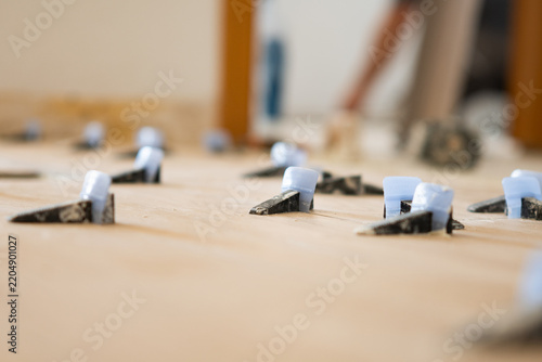 Tile leveling system wedges securing flooring installation