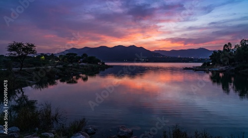 sunset sunrise water mountains sky clouds nature reflection landscape scenic wilderness horizon evening twilight orange purple blue pink colors calm peaceful tranquil serene