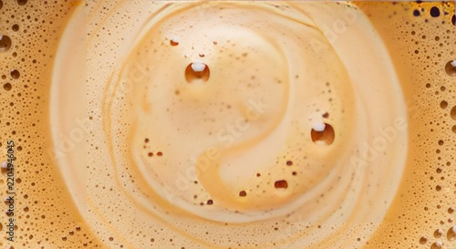 Close-up macro shot of creamy coffee foam with swirling patterns and small bubbles.