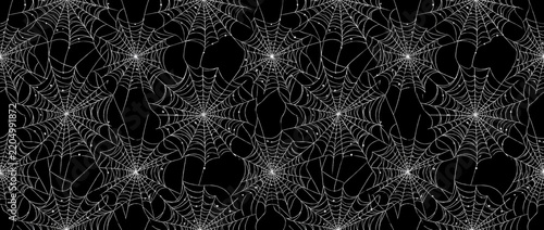 Seamless repeating pattern of white spider webs and cobwebs on solid black background, spooky Halloween texture