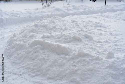 Photo of snow on the ground in the winter evening. Path in the white snow with footprints on cold day.