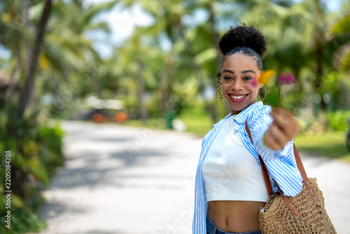 Stylish woman in trendy summer outfit posing in a bright tropical environment on summer vacation