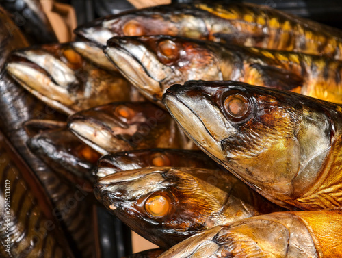 Hot smoked mackerel with head arranged on a supermarket seafood display, showing a gutted fish product prepared and presented for shoppers