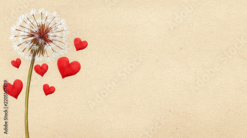 Dandelion seed head with red paper hearts on warm textured background, delicate botanical still life symbolizing affection and romance with generous copy space for design
