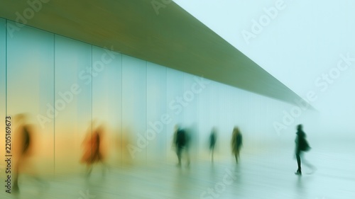 People moving through a modern architectural space with motion blur creating a sense of anonymity and passage