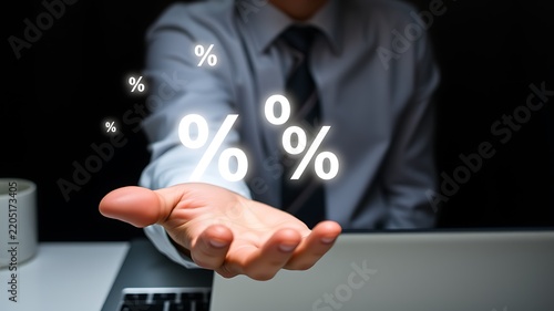 A businessman in a shirt and tie with glowing percentage symbols floating above his open palm, symbolizing financial growth and interest