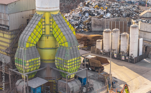 Aerial view of the industrial air filtration and exhaust system at the Alfa Acciai steel plant, with scrap metal storage and storage tanks in Brescia, Lombardy, Italy.
