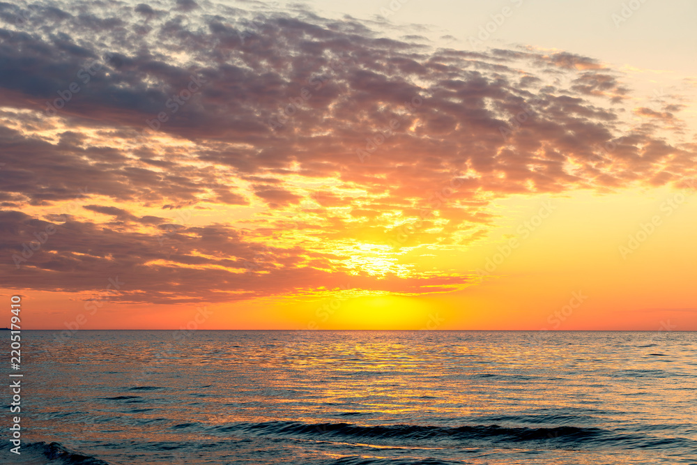 Obraz premium Colorful sunset over calm ocean horizon scene