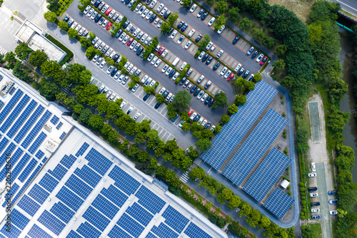 tree-lined parking lot beside solar rooftop factory
