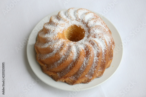 Cuadro en lienzo Homemade lemon bundt cake with icing sugar against white background