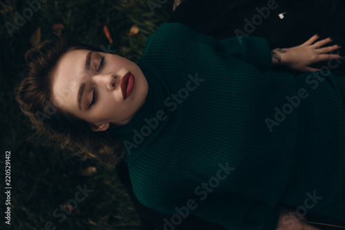 Canvastavla Serene autumn moments captured as a woman rests peacefully on the grass