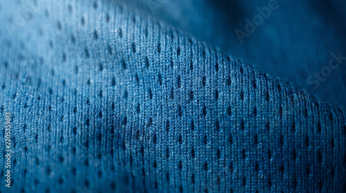 A high-detail macro shot showing the textured pattern of blue moisture-wicking synthetic fabric used in athletic sportswear and gym apparel.