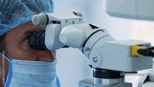 Fotografie Close-up of ophthalmic surgeon looking through surgical microscope eyepiece duri