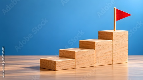 Wooden blocks stacked as stairs leading to a red flag on top symbolizing achievement success and reaching goals in a conceptual business context.