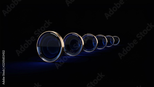Set of deep blue circular glass objects with metallic borders on black surface as transparent cutout