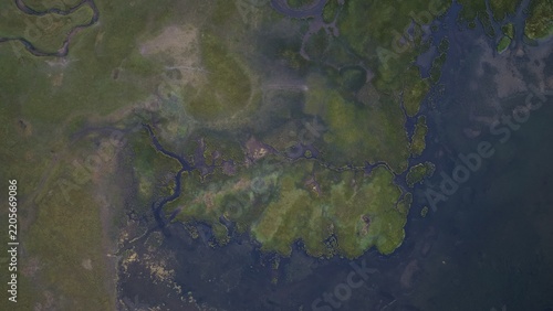 Aerial view of Song-Kul lake with winding streams and marshy green shoreline, Naryn Region, Kyrgyzstan.