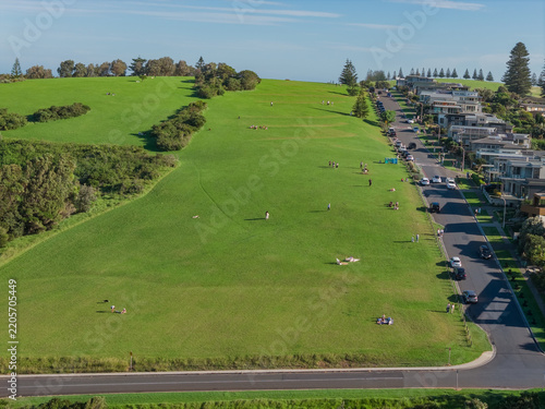 Aerial view of a winding road on a sloping green hillside