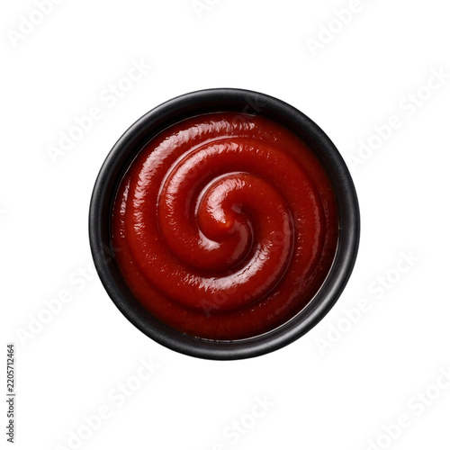 Delicious tomato ketchup or red chili sauce swirled neatly inside a small dark round bowl presented isolated on transparent background