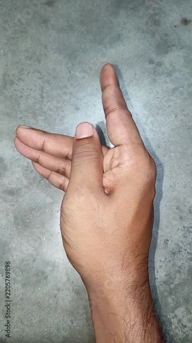 Close up of a male hand making a beckoning gesture with the index finger to summon or invite