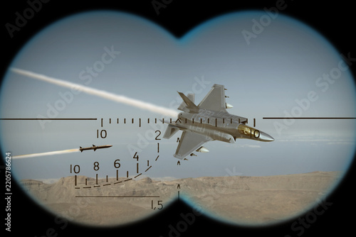 Fotografie A fighter jet shoots down a missile, as seen through binoculars during an aerial dogfight