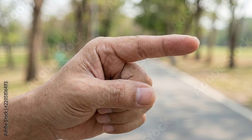 Close up of human hand pointing finger to the right outdoors