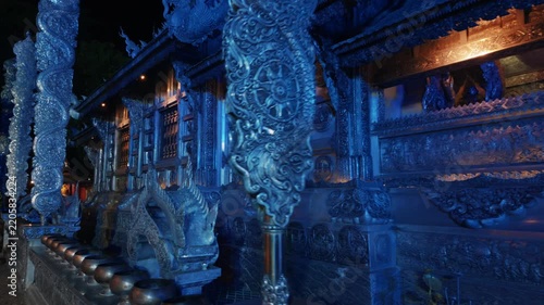 silver temple Wat Sri Suphan illuminated with blue light at night, ornate carved metal architecture facade in Thai shrine landmark at Chiang Mai 4k