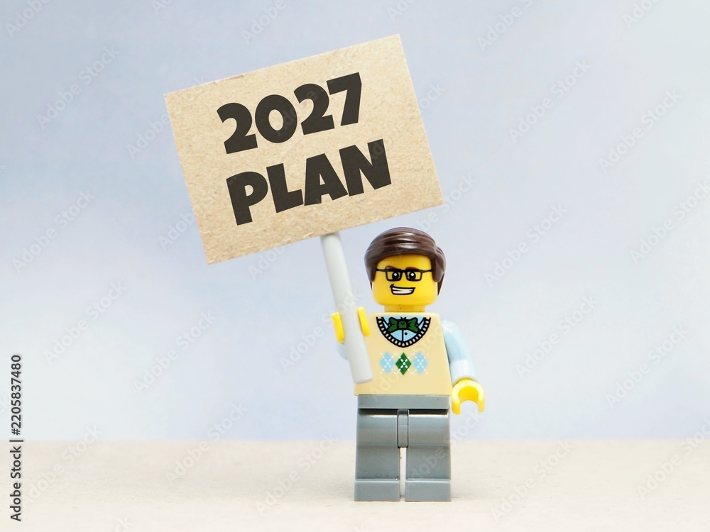 Obraz premium Indonesia - June 12, 2026 : Mini toy of action figure at table with blurred background. Business Miniature photography concept design. Minifigure of people with 2027 PLAN text at paper poster banner.
