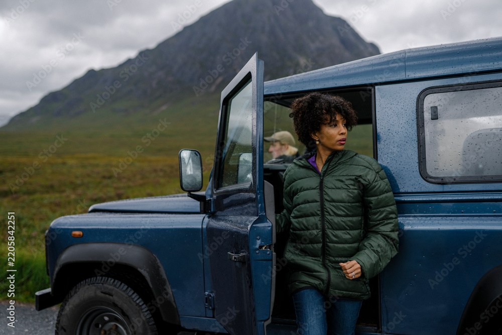 Fototapeta premium Woman getting out of her car in the Highlands