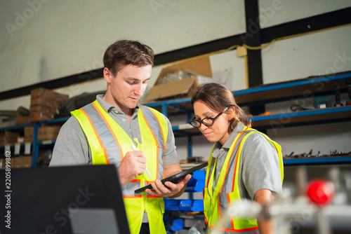 Manufacturing Engineers Examining Mechanical Part in Factory Workshop
