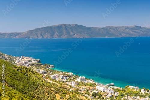 Seaside landscape near the city of Vlore in Albania, Europe. Breathtaking panoramic view of a coastal resort town nestled between lush green mountains and a deep blue sea