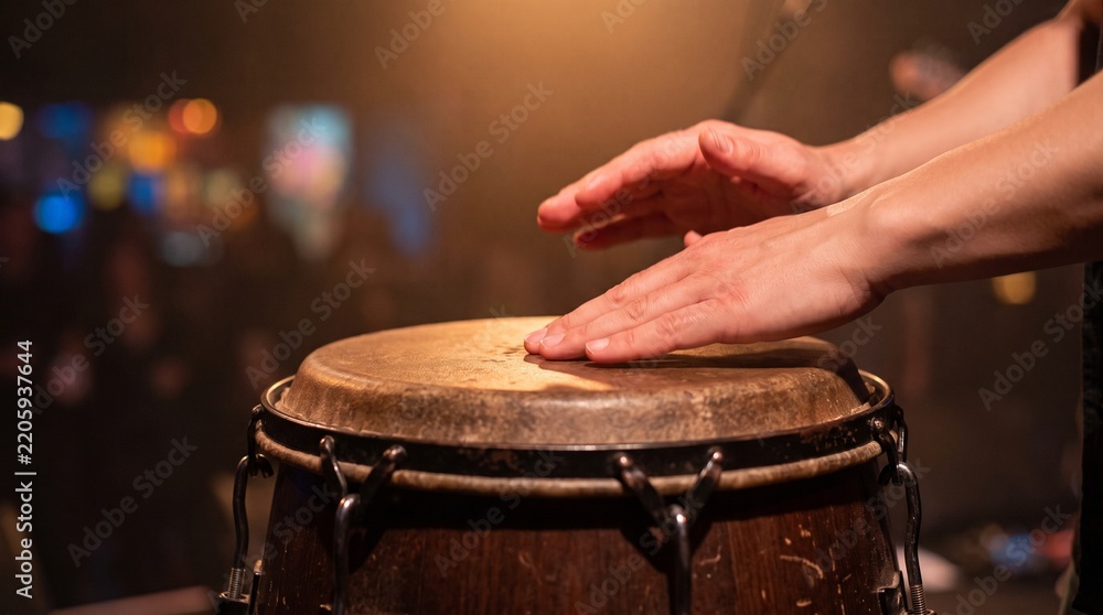 Obraz premium Musician Hands Playing Conga Drum On Concert Stage with Warm Lighting