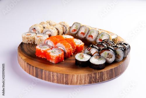 Assorted sushi rolls on wooden serving platter fine dining food