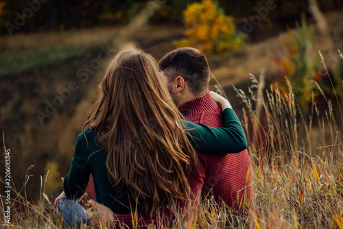 Couple embracing outdoors during autumn season.