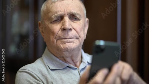Senior man using a mobile phone, indoor lifestyle scene.