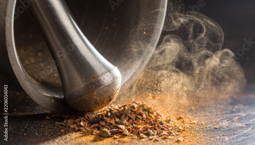 Dynamic motion of fine spice particles being ground into powder within a mortar and pestle