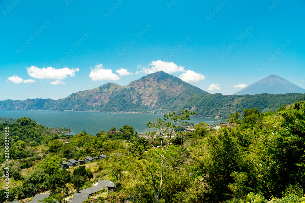 Naklejka premium Scenic landscape view of Mount Batur and Lake Batur with Mount Agung in background under blue sky, Kintamani, Bali, Indonesia